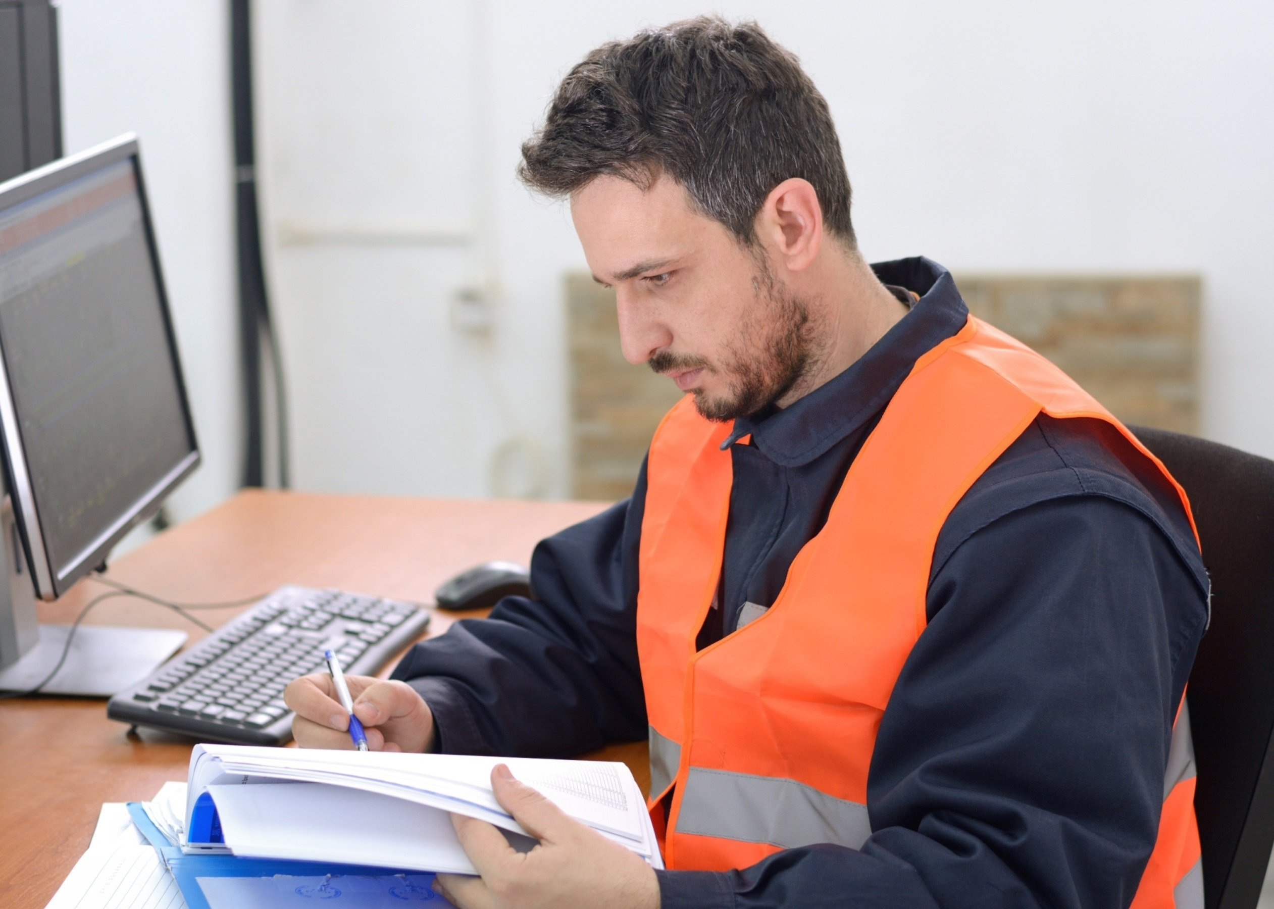 Industrial Control Systems  - Man taking notes in front of computer