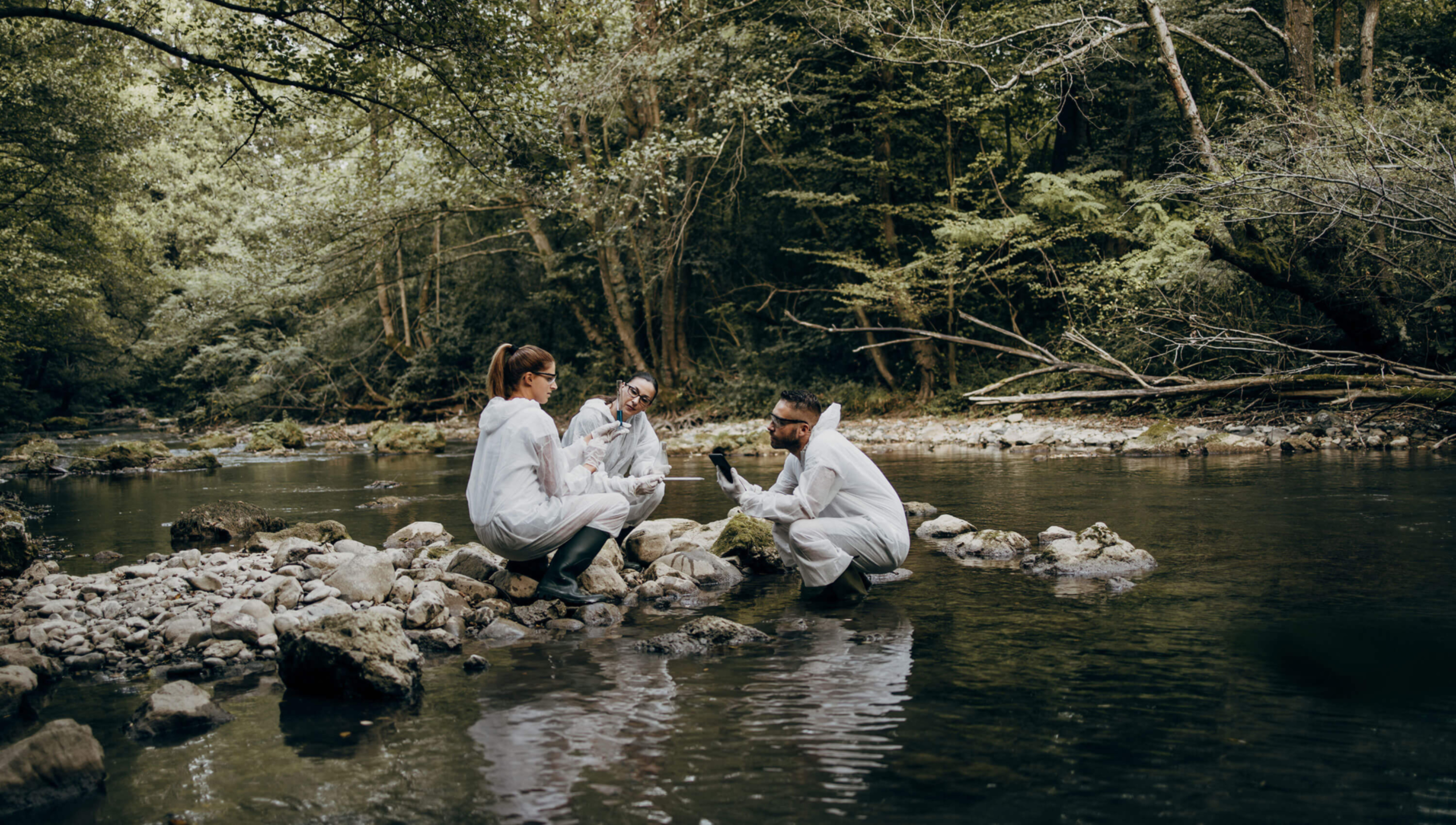 Environment - 3 people taking samples in river forest