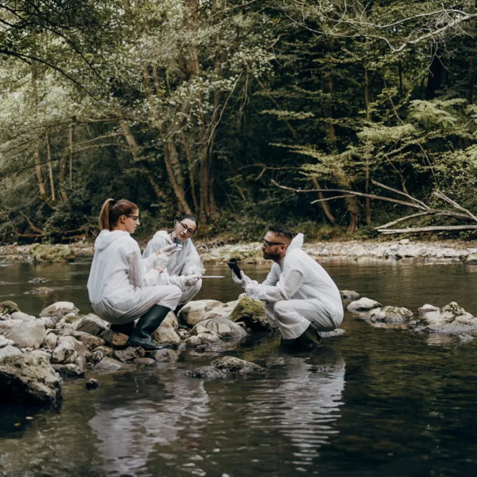 Environment - 3 people taking samples in river forest